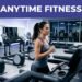 A woman runs on a treadmill inside a modern, well-lit fitness center at night.
