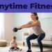 A mother works out with a kettlebell in her living room while her toddler plays.