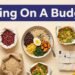 An overhead view of budget groceries and a healthy meal bowl on a cream background.