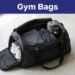 An open black gym bag holds clothes, white sneakers, a towel, and a water bottle.