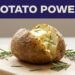 A split baked potato with melting butter and rosemary on a wooden board.