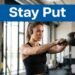 Woman doing a kettlebell swing while wearing black workout headphones.