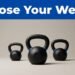 Three graduated kettlebells beneath a blue banner, with the medium one in focus.